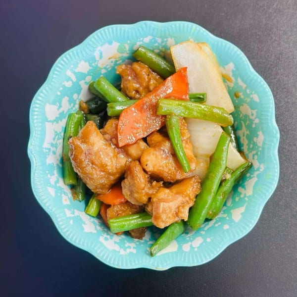 A close-up of My City Chinese Foods' chicken stir-fry with green beans, red peppers, and onions.