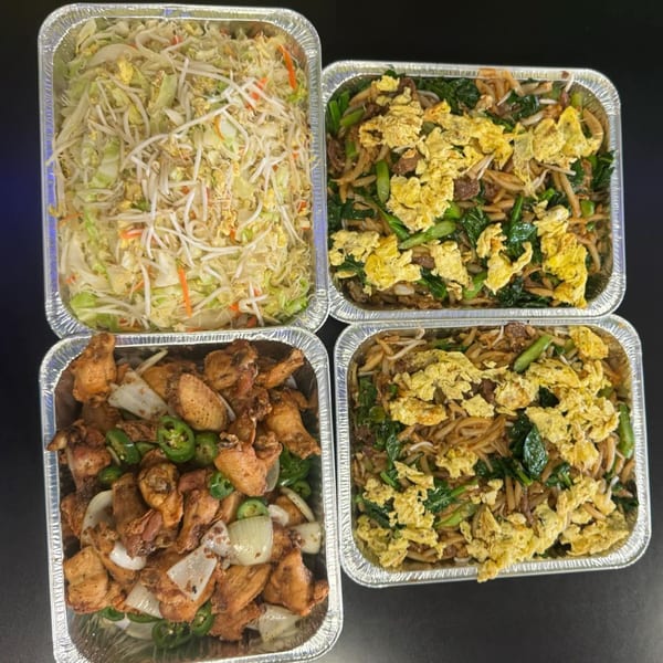 Four aluminum trays of Chinese food, including chow mein, fried chicken, and stir-fried vegetables.