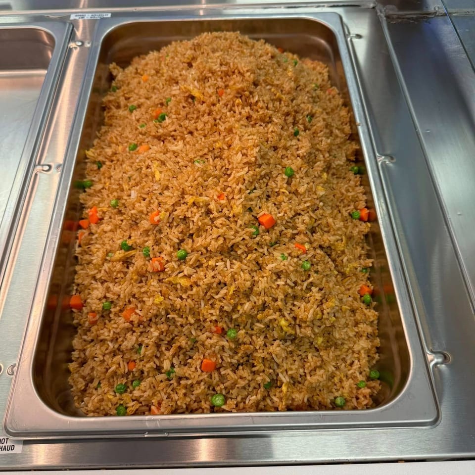 A large metal tray filled with My City Chinese Foods' fried rice, featuring peas and carrots.