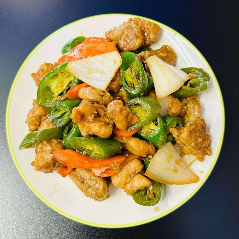 My City Chinese Foods' stir-fried chicken with green peppers, red peppers, and onions on a white plate.