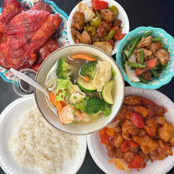 A vibrant spread of Chinese dishes, including red chicken, sweet and sour chicken, and wonton soup.