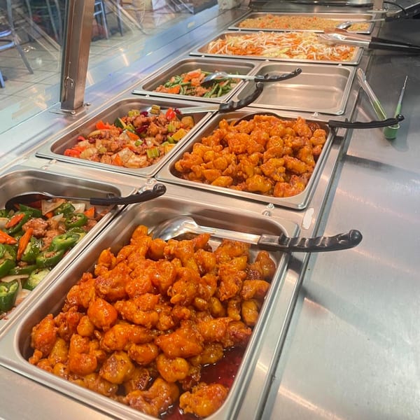A buffet line at My City Chinese Foods with various Chinese dishes, including orange chicken and stir-fries.