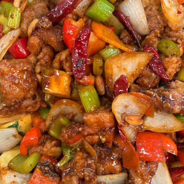 Close-up of My City Chinese Foods' Kung Pao Chicken with peppers, onions, and peanuts.