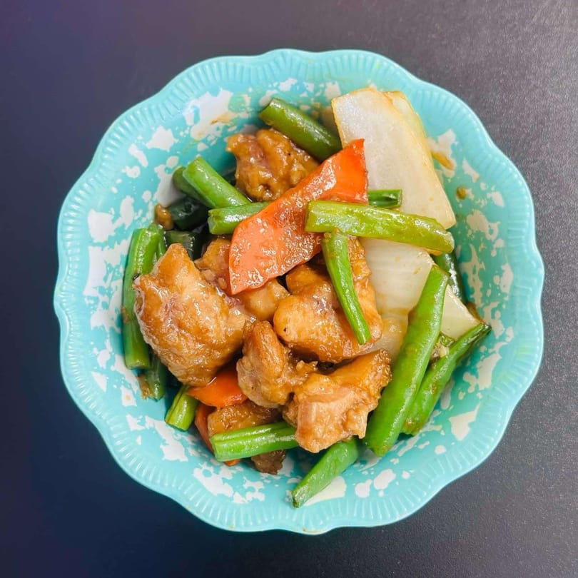 My City Chinese Foods' chicken stir-fry with green beans, red peppers, and onions in a blue bowl.