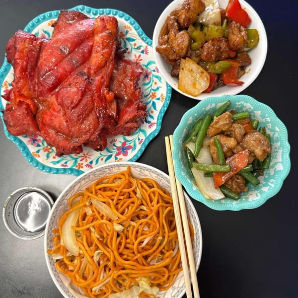 A vibrant spread of Chinese dishes: red roasted pork, sweet and sour chicken, green bean chicken, and lo mein.