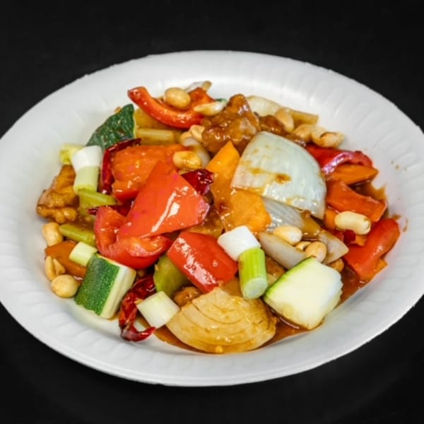 Kung Pao chicken with peanuts, red bell peppers, zucchini, and onions in a rich sauce.